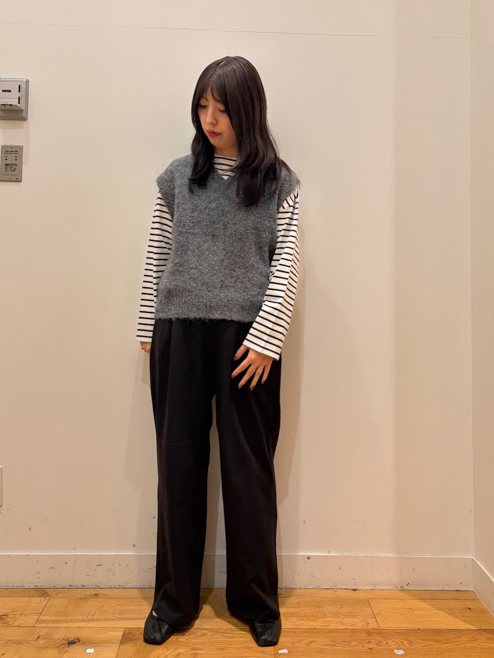 グレー系のベスト、ホワイト系のTシャツ/カットソー、ブラック系のその他パンツを着用したレディースの秋コーディネートの2枚目の写真