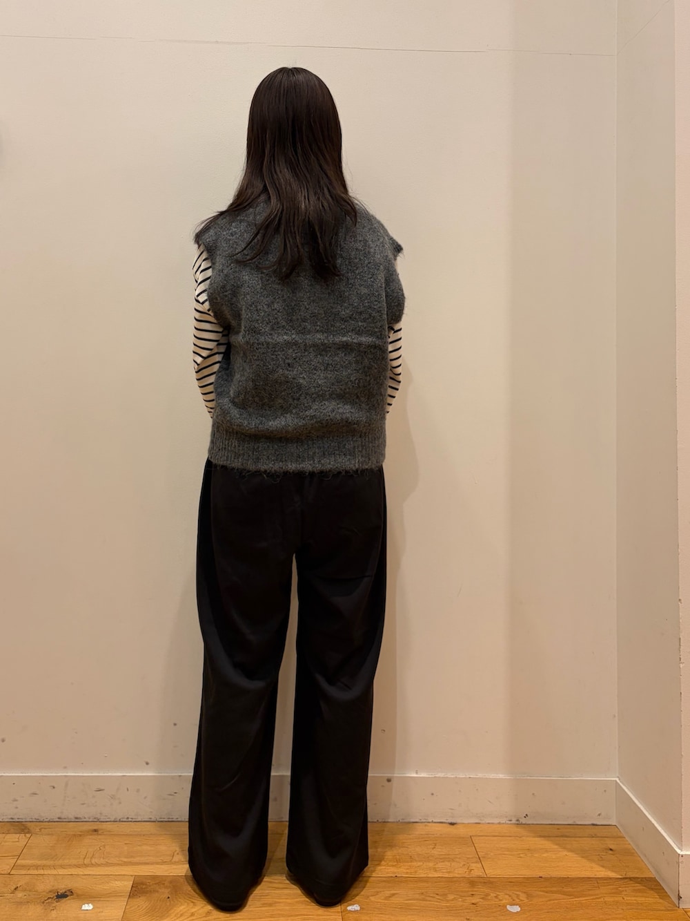 グレー系のベスト、ホワイト系のTシャツ/カットソー、ブラック系のその他パンツを着用したレディースの秋コーディネートの3枚目の写真
