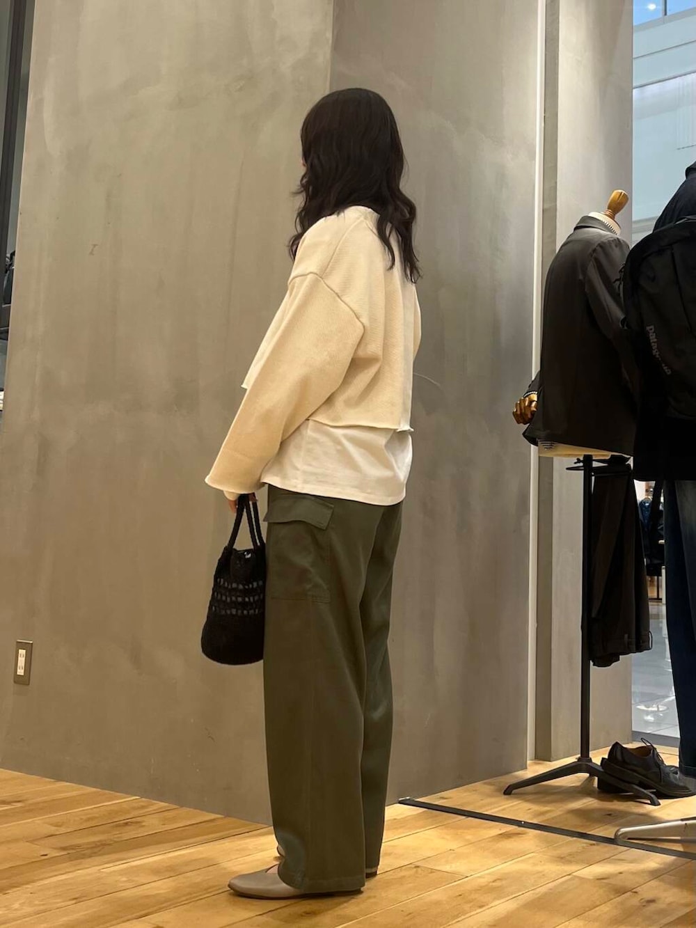 グレー系のパンプス、ホワイト系のTシャツ/カットソー、ブラック系のショルダーバッグを着用したレディースの冬コーディネートの4枚目の写真