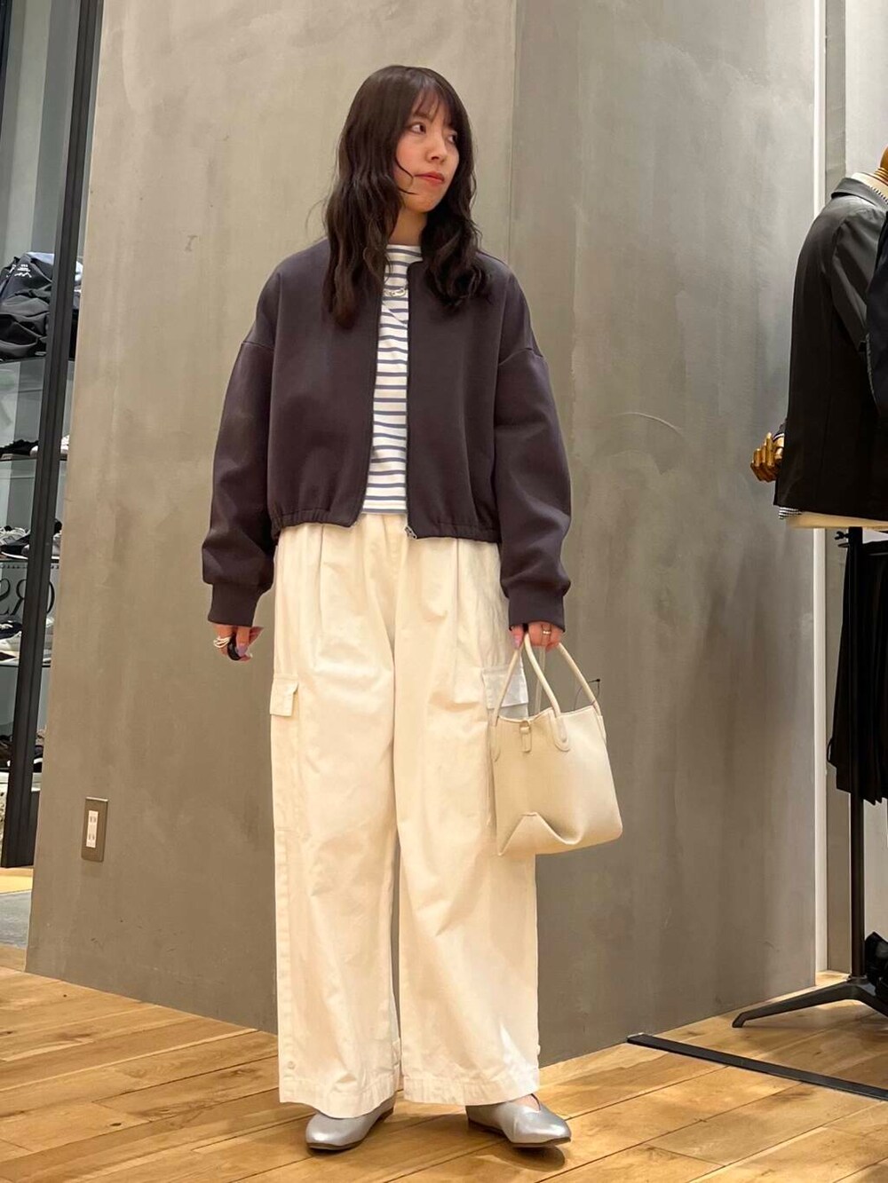 ホワイト系のその他パンツ、シルバー系のパンプス、ホワイト系のハンドバッグを着用したレディースの春コーディネートの2枚目の写真