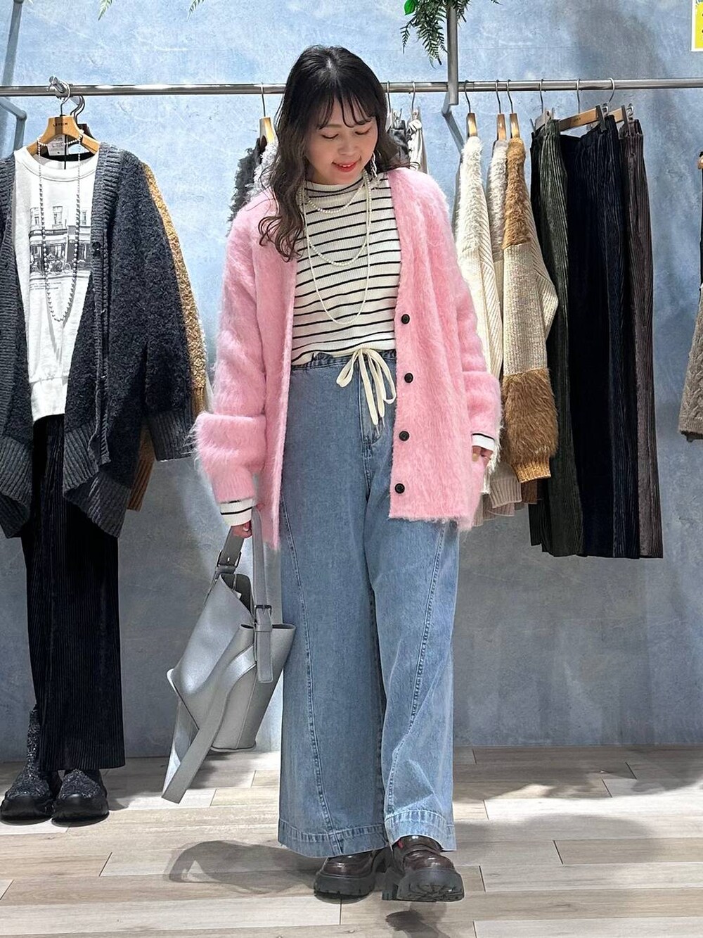 ブラウン系のローファー、ブルー系のデニムパンツ、ホワイト系のニット/セーターを着用したレディースの秋コーディネートの6枚目の写真