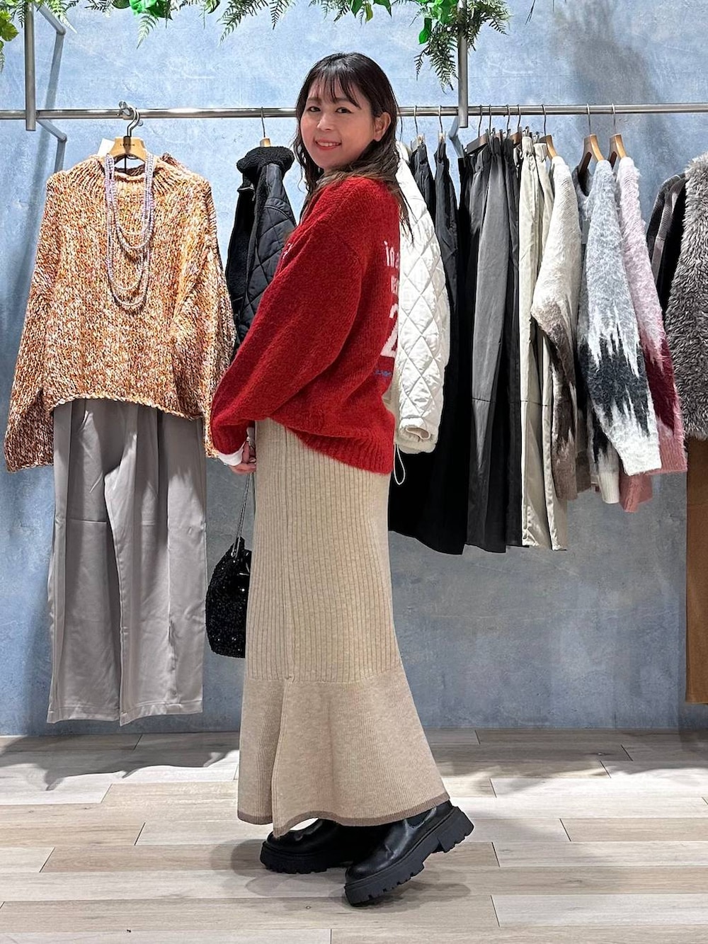 ホワイト系のTシャツ/カットソー、ブラウン系のスカート、レッド系のニット/セーターを着用したレディースの秋コーディネートの2枚目の写真