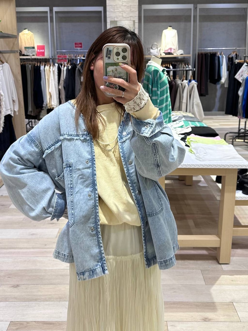 イエロー系のスウェット、ブルー系のシャツ/ブラウス、ホワイト系のスカートを着用したレディースの冬コーディネートの2枚目の写真