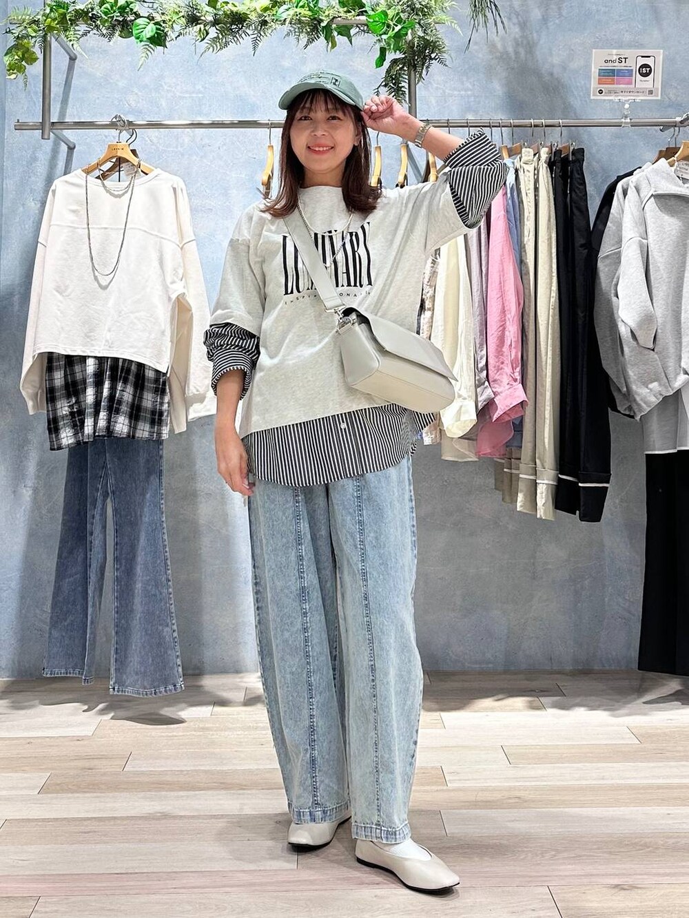 グレー系のショルダーバッグ、ホワイト系のパンプス、グレー系のTシャツ/カットソーを着用したレディースの春コーディネートの2枚目の写真