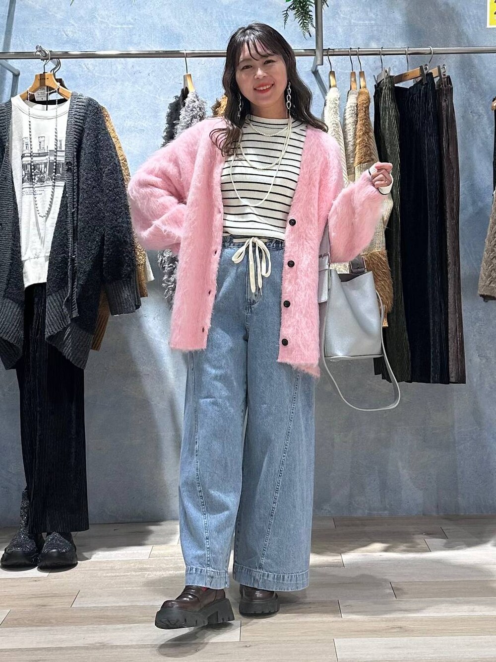 ブラウン系のローファー、ブルー系のデニムパンツ、ホワイト系のニット/セーターを着用したレディースの秋コーディネートの7枚目の写真