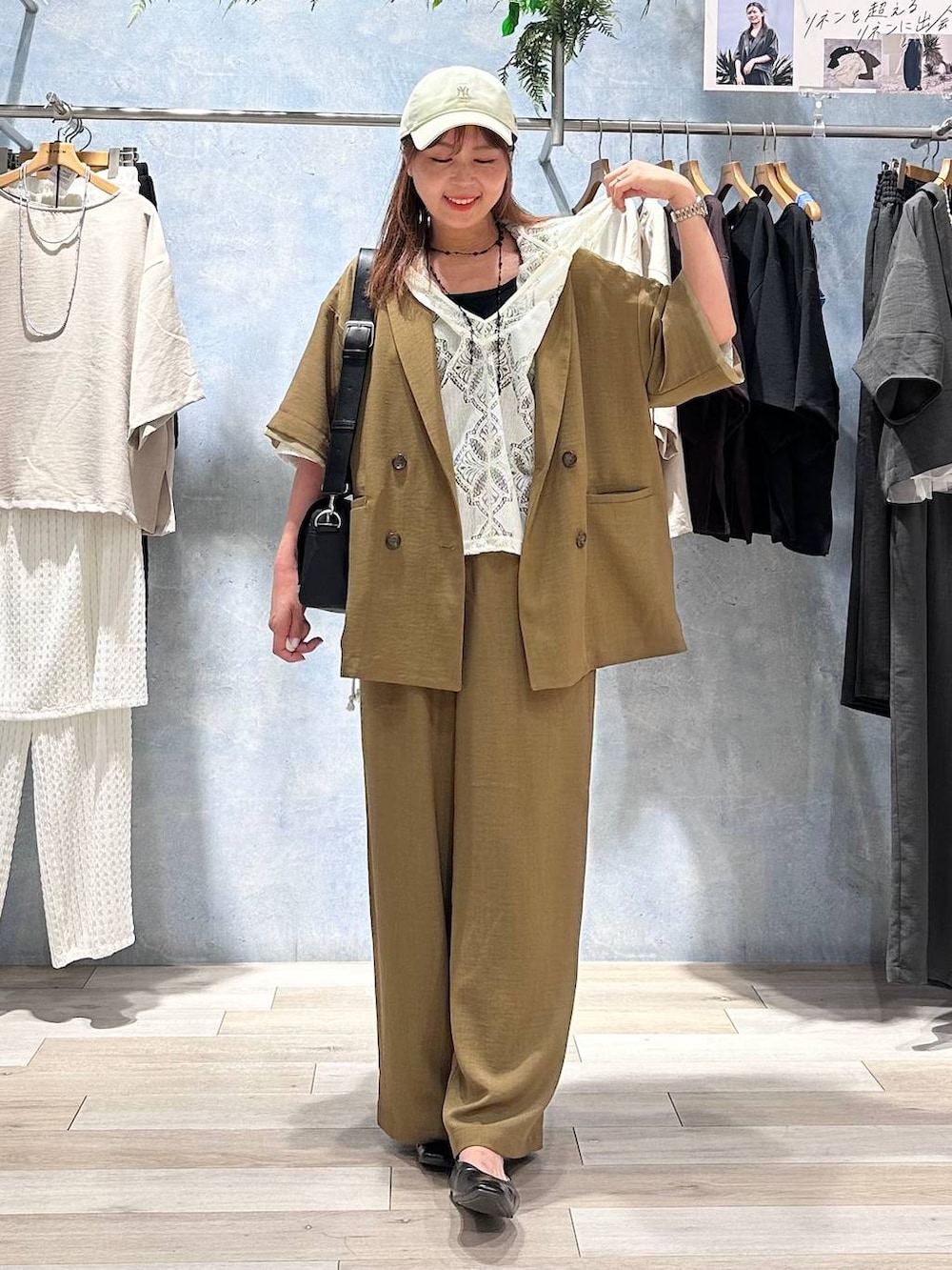 ブラック系のショルダーバッグ、ブラック系のパンプス、ブラウン系のその他パンツを着用したレディースの春コーディネートの2枚目の写真