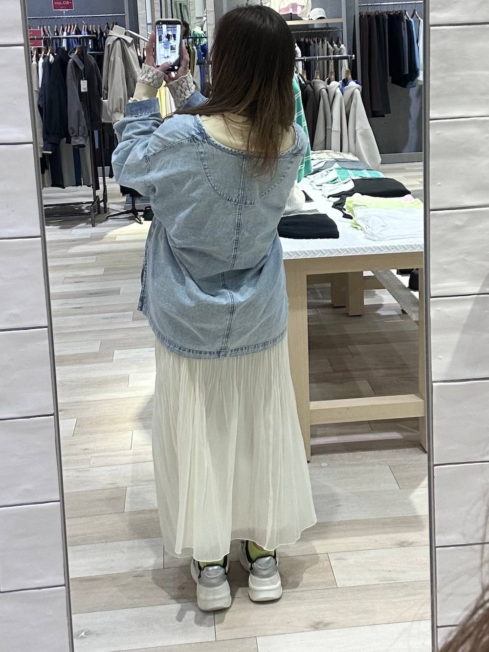 イエロー系のスウェット、ブルー系のシャツ/ブラウス、ホワイト系のスカートを着用したレディースの冬コーディネートの4枚目の写真