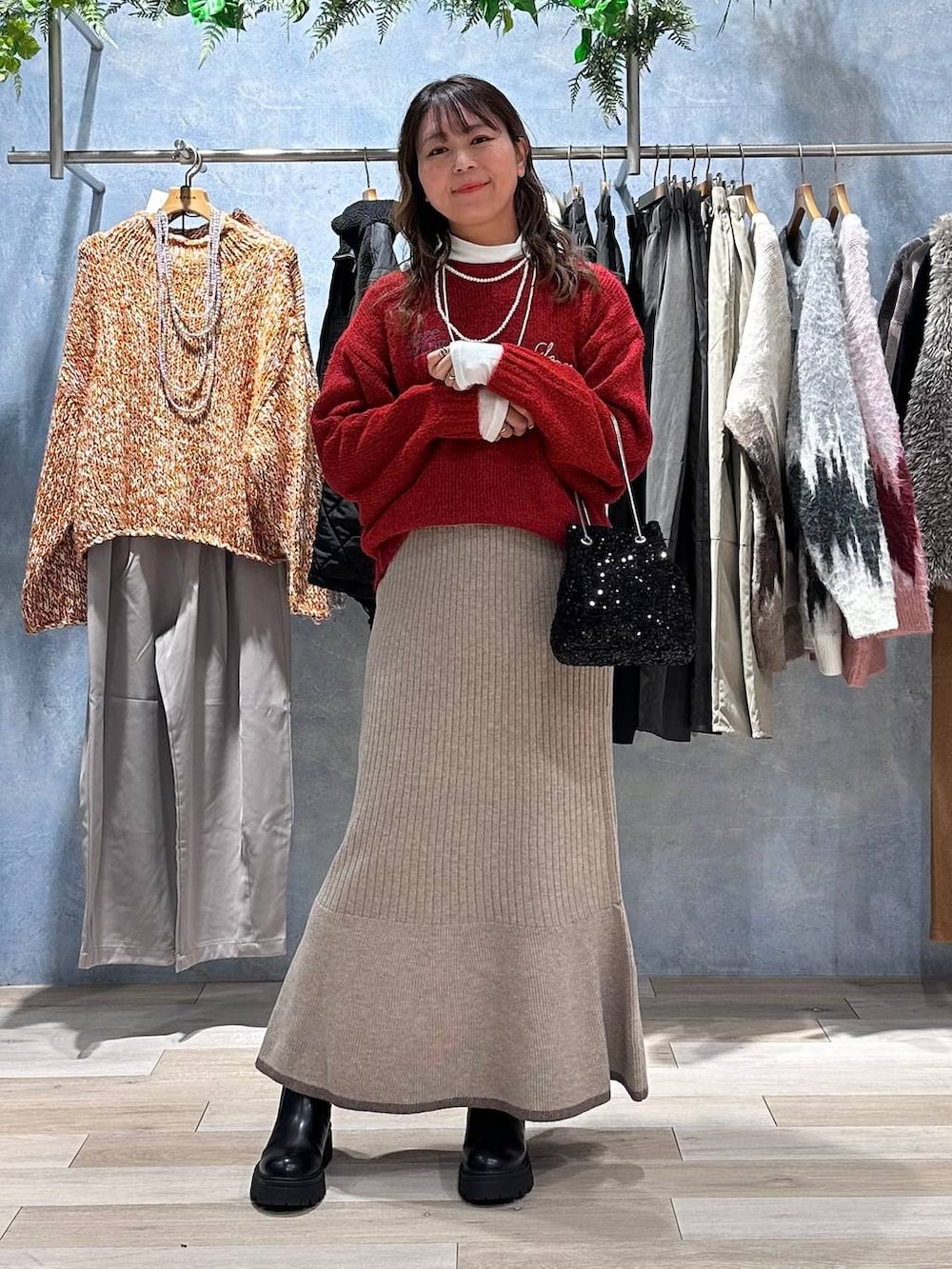 ホワイト系のTシャツ/カットソー、ブラウン系のスカート、レッド系のニット/セーターを着用したレディースの秋コーディネートの3枚目の写真