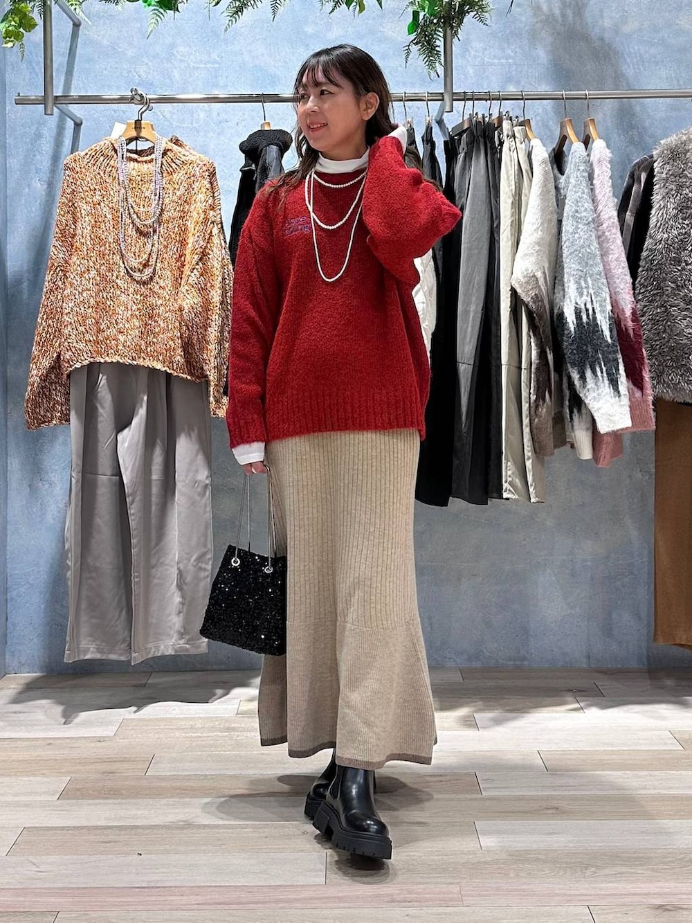ホワイト系のTシャツ/カットソー、ブラウン系のスカート、レッド系のニット/セーターを着用したレディースの秋コーディネートの4枚目の写真