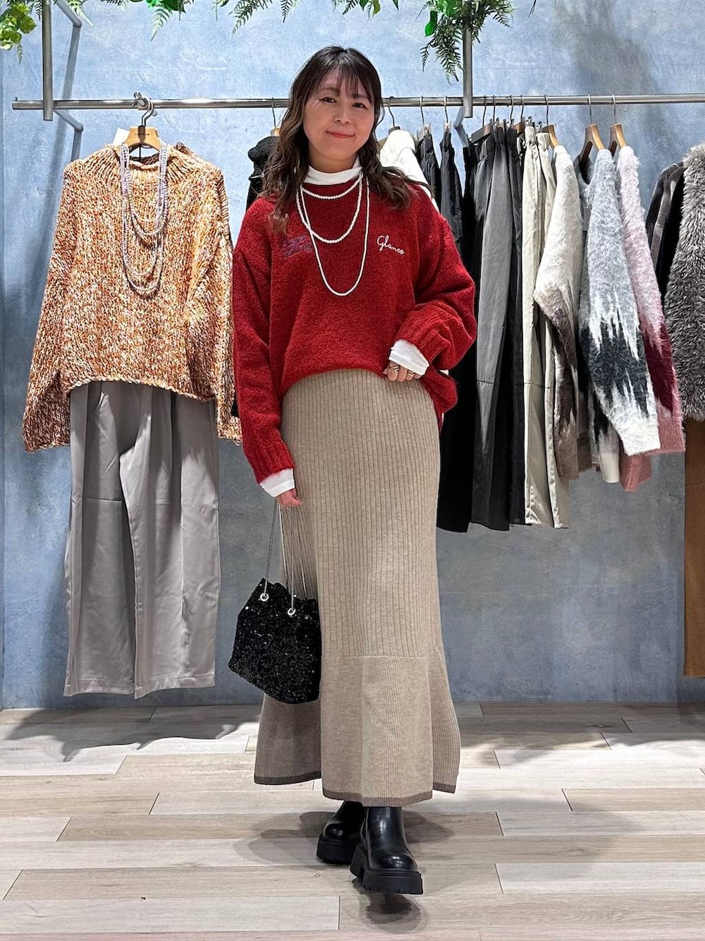 ホワイト系のTシャツ/カットソー、ブラウン系のスカート、レッド系のニット/セーターを着用したレディースの秋コーディネートの8枚目の写真