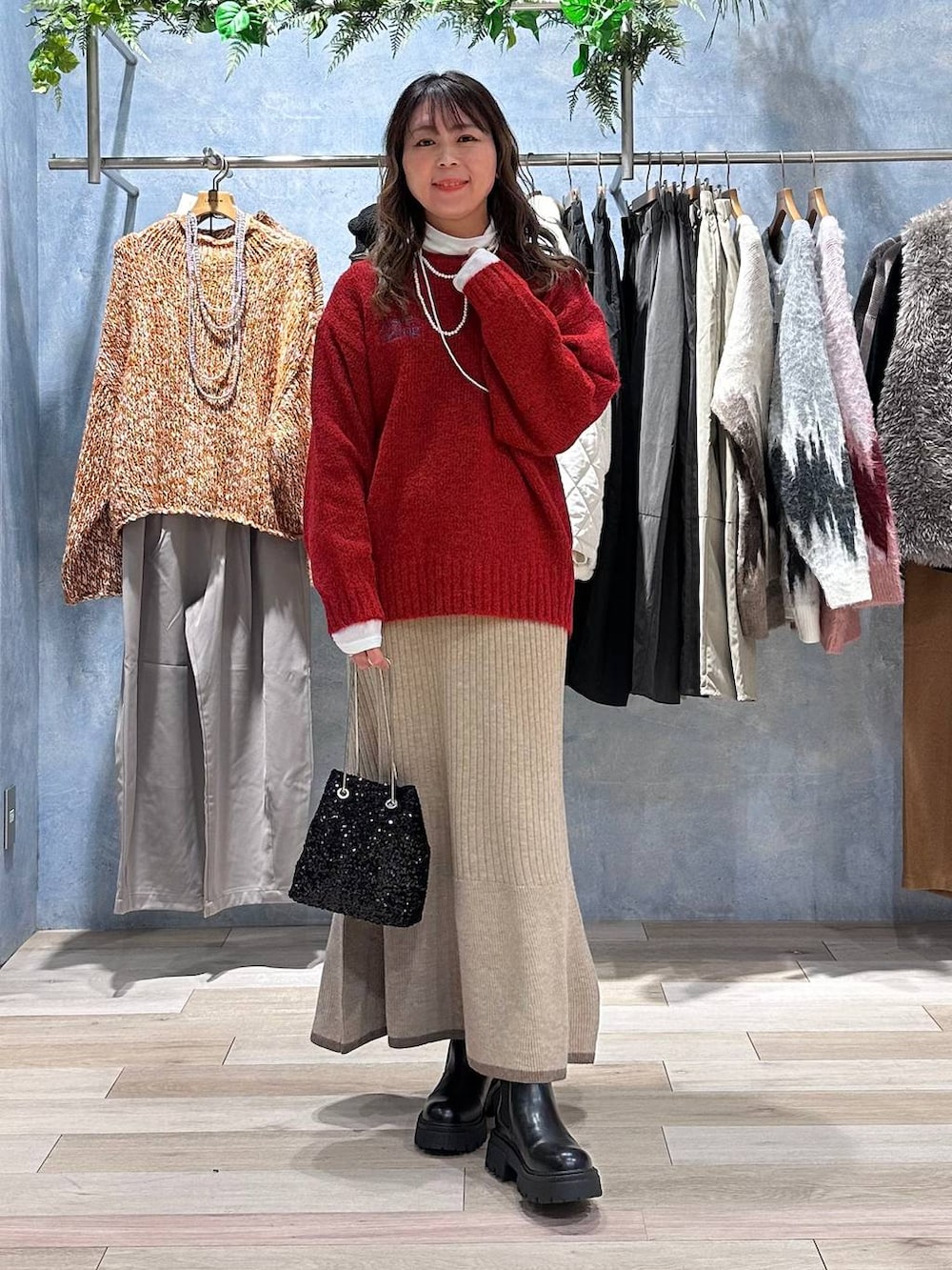 ホワイト系のTシャツ/カットソー、ブラウン系のスカート、レッド系のニット/セーターを着用したレディースの秋コーディネートの7枚目の写真