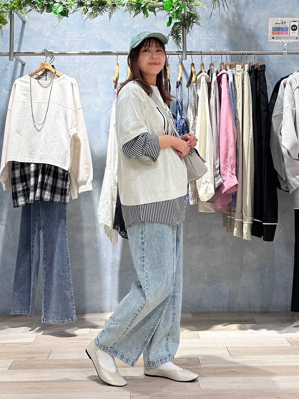 グレー系のショルダーバッグ、ホワイト系のパンプス、グレー系のTシャツ/カットソーを着用したレディースの春コーディネートの3枚目の写真