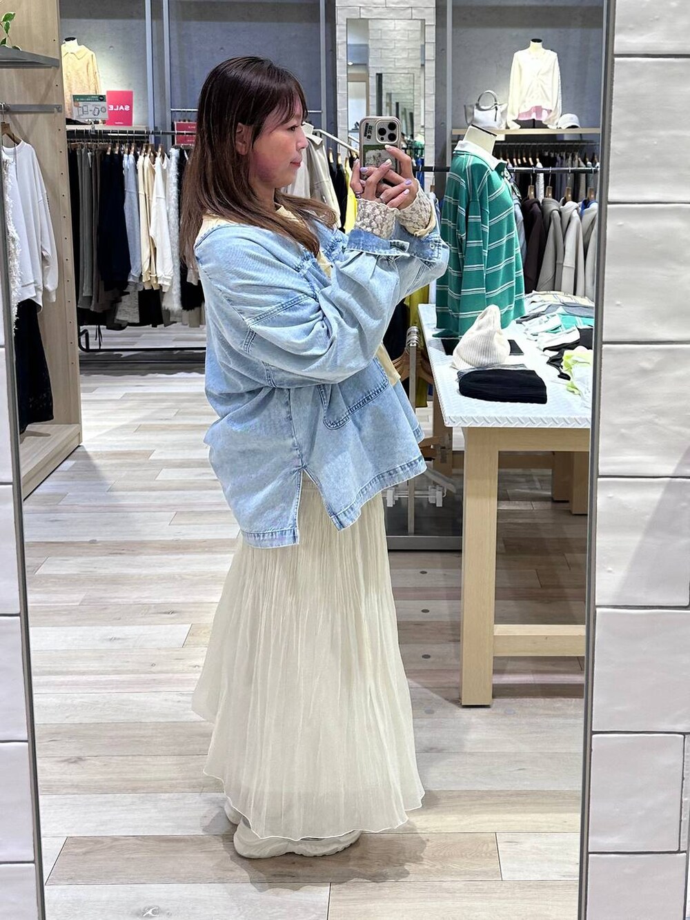 イエロー系のスウェット、ブルー系のシャツ/ブラウス、ホワイト系のスカートを着用したレディースの冬コーディネートの3枚目の写真