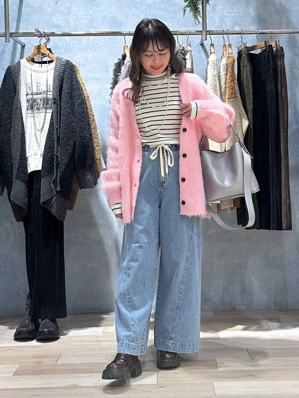 ブラウン系のローファー、ブルー系のデニムパンツ、ホワイト系のニット/セーターを着用したレディースの秋コーディネートの2枚目の写真