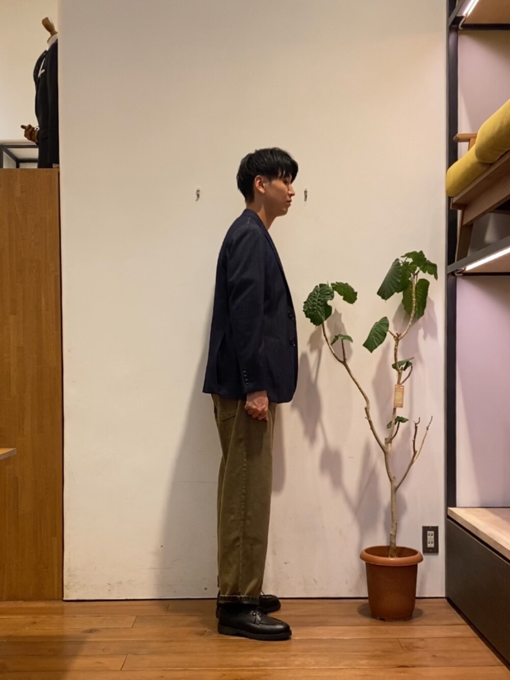 ブラウン系のデニムパンツ、ブラック系のドレスシューズ、ホワイト系のTシャツ/カットソーを着用したメンズの秋コーディネートの3枚目の写真