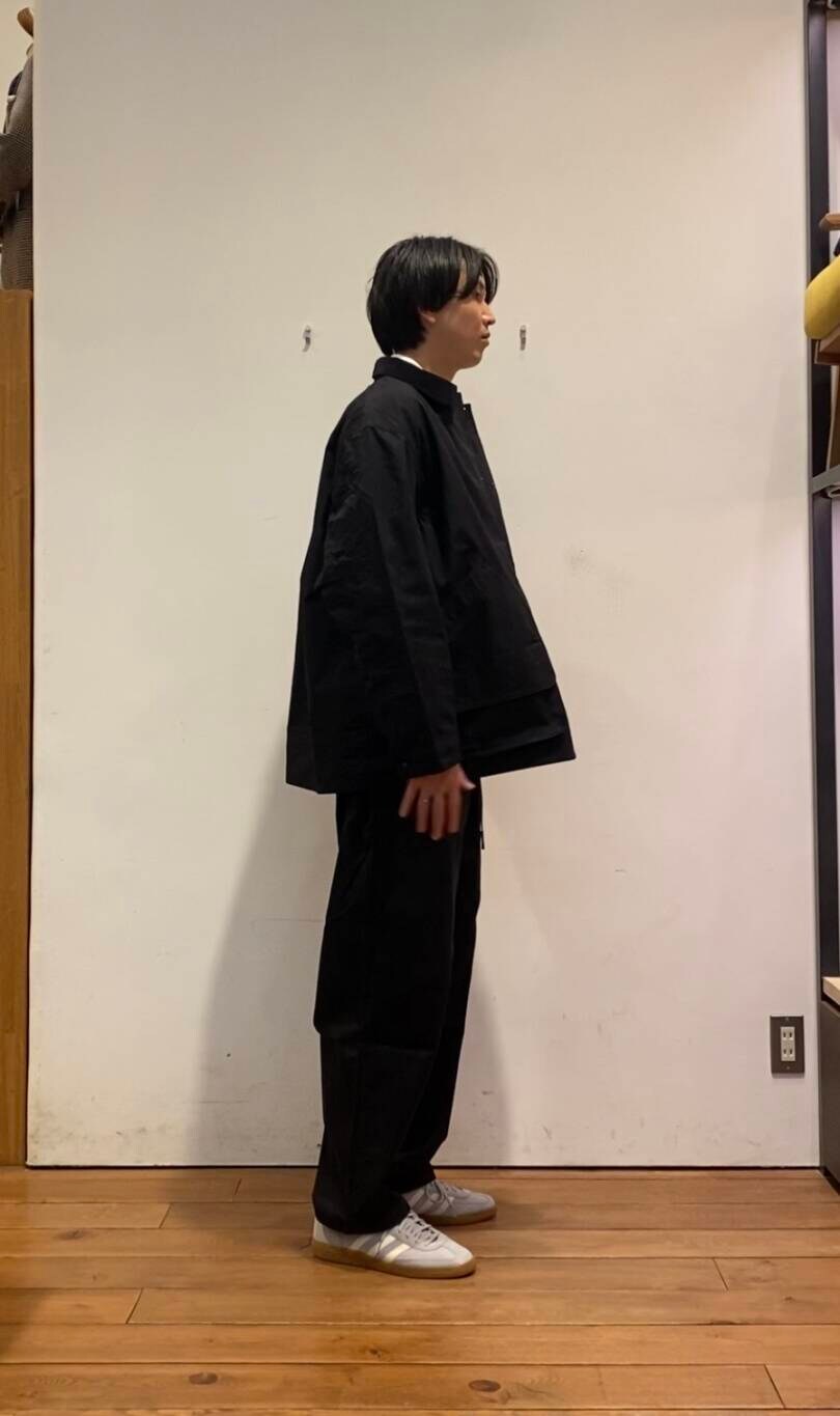 ブラック系のデニムパンツ、ホワイト系のスウェット、グレー系のスニーカーを着用したメンズの冬コーディネートの3枚目の写真