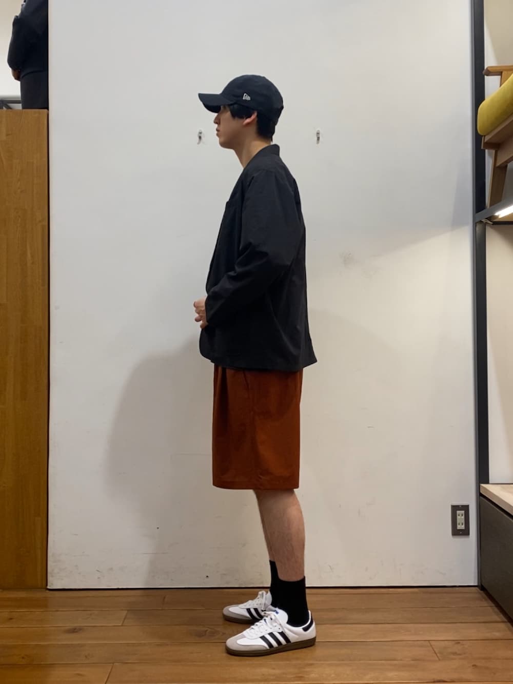 ブラック系のその他アウター、ブラウン系のTシャツ/カットソー、オレンジ系のその他パンツを着用したメンズの春コーディネートの2枚目の写真