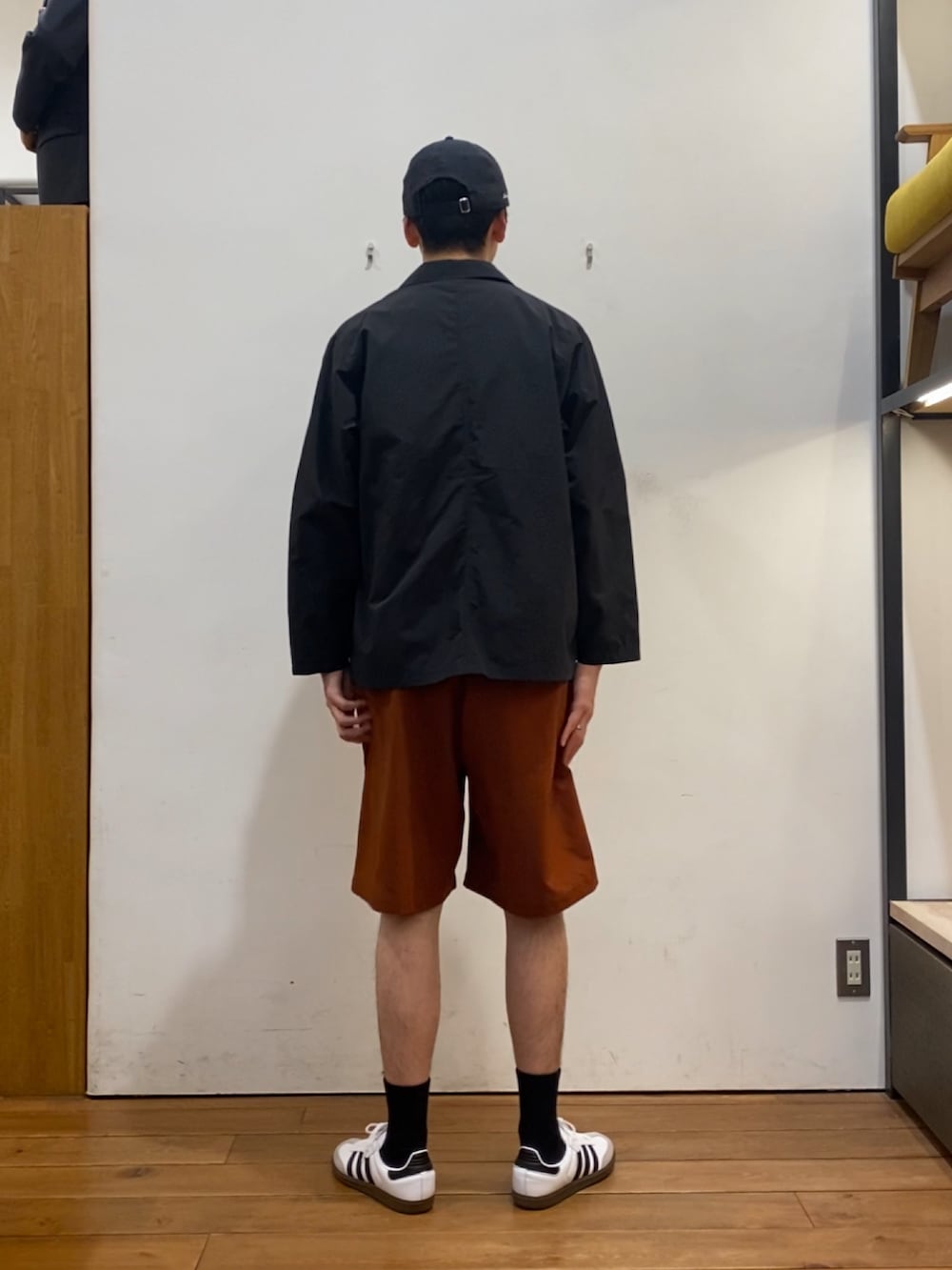 ブラック系のその他アウター、ブラウン系のTシャツ/カットソー、オレンジ系のその他パンツを着用したメンズの春コーディネートの4枚目の写真