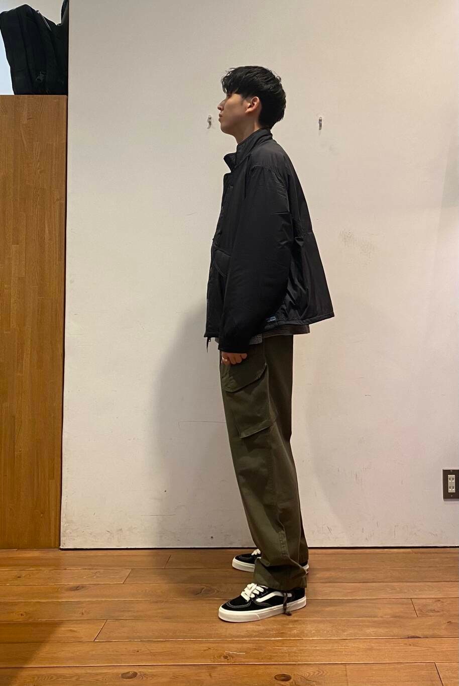 グリーン系のバックパック/リュック、ブラック系のTシャツ/カットソー、グリーン系のその他パンツを着用したメンズの秋コーディネートの5枚目の写真