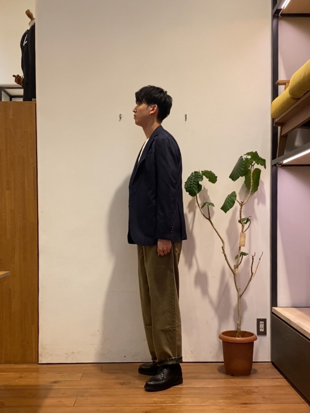 ブラウン系のデニムパンツ、ブラック系のドレスシューズ、ホワイト系のTシャツ/カットソーを着用したメンズの秋コーディネートの2枚目の写真