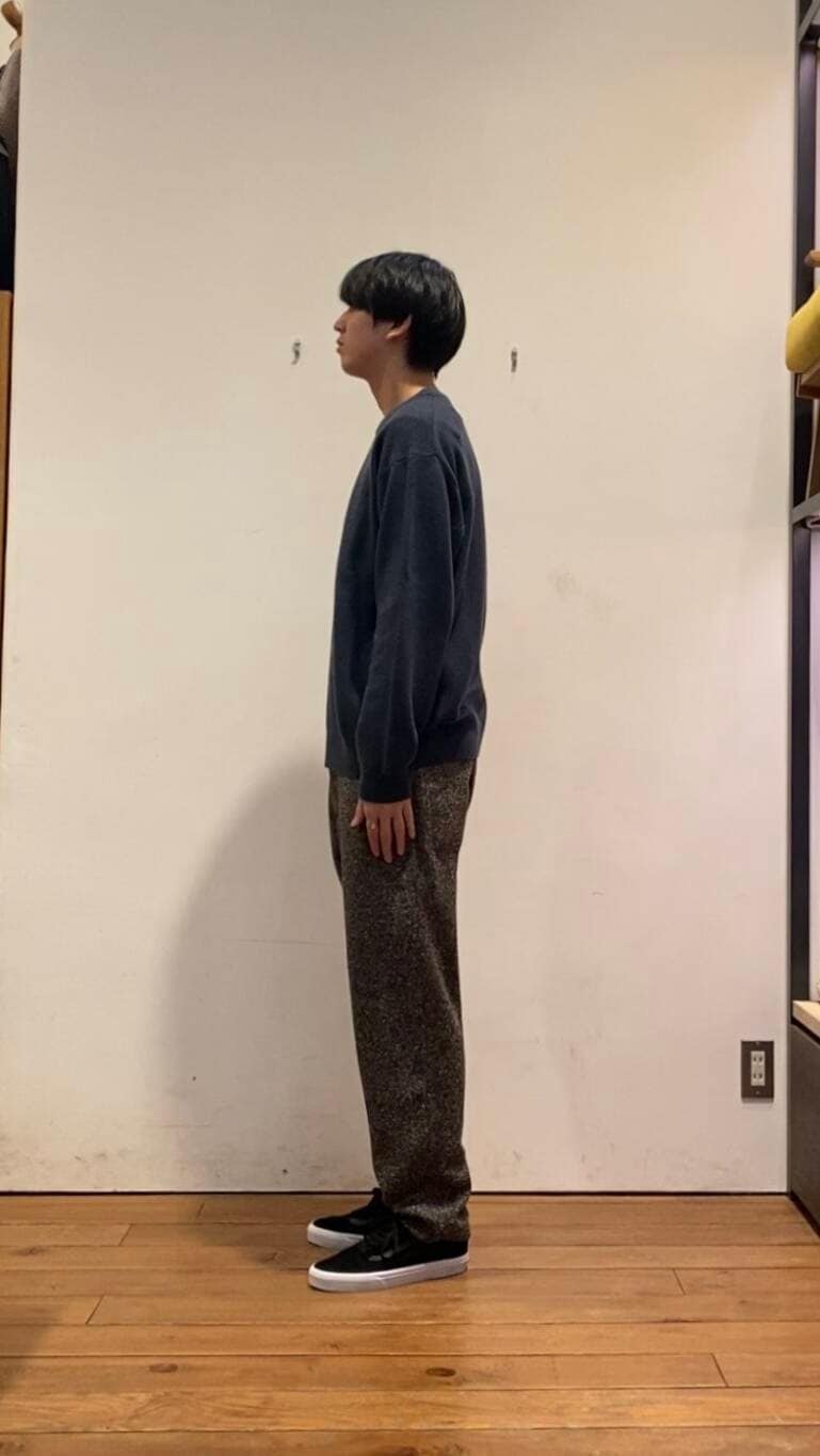 ホワイト系のダウンジャケット/コート、ブルー系のニット/セーター、ブラウン系のその他パンツを着用したメンズの冬コーディネートの4枚目の写真