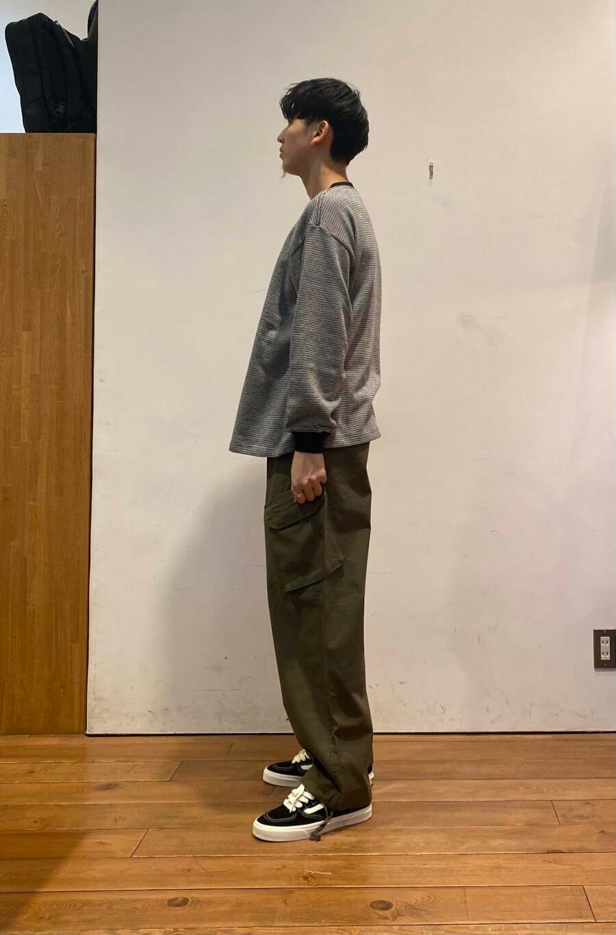 グリーン系のバックパック/リュック、ブラック系のTシャツ/カットソー、グリーン系のその他パンツを着用したメンズの秋コーディネートの9枚目の写真