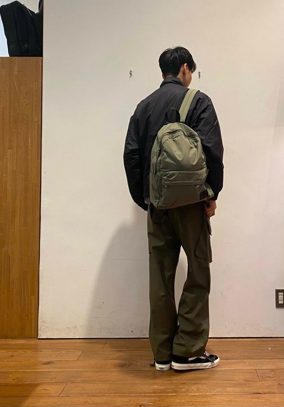 グリーン系のバックパック/リュック、ブラック系のTシャツ/カットソー、グリーン系のその他パンツを着用したメンズの秋コーディネートの3枚目の写真