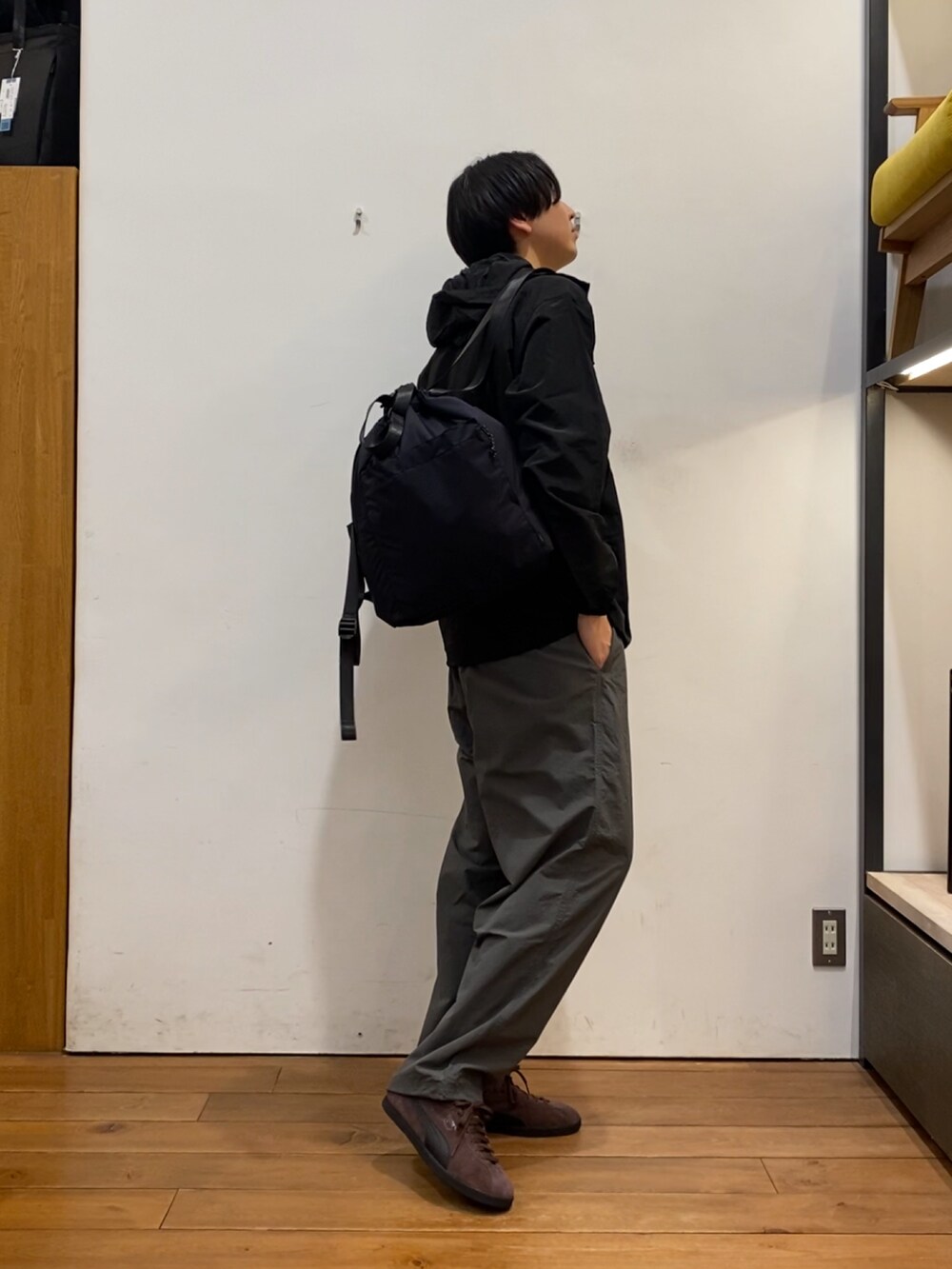 ブラック系のパーカー、グレー系のその他パンツ、ブラウン系のスニーカーを着用したメンズの冬コーディネートの2枚目の写真