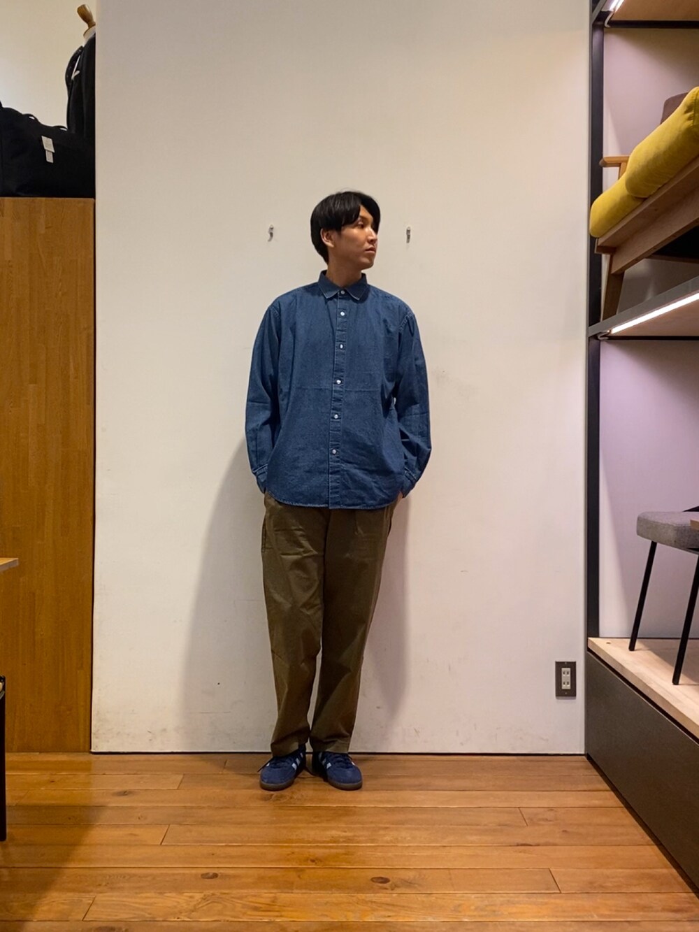 ブルー系のスニーカー、ブラック系のテーラードジャケット、グリーン系のその他パンツを着用したメンズの秋コーディネートの5枚目の写真