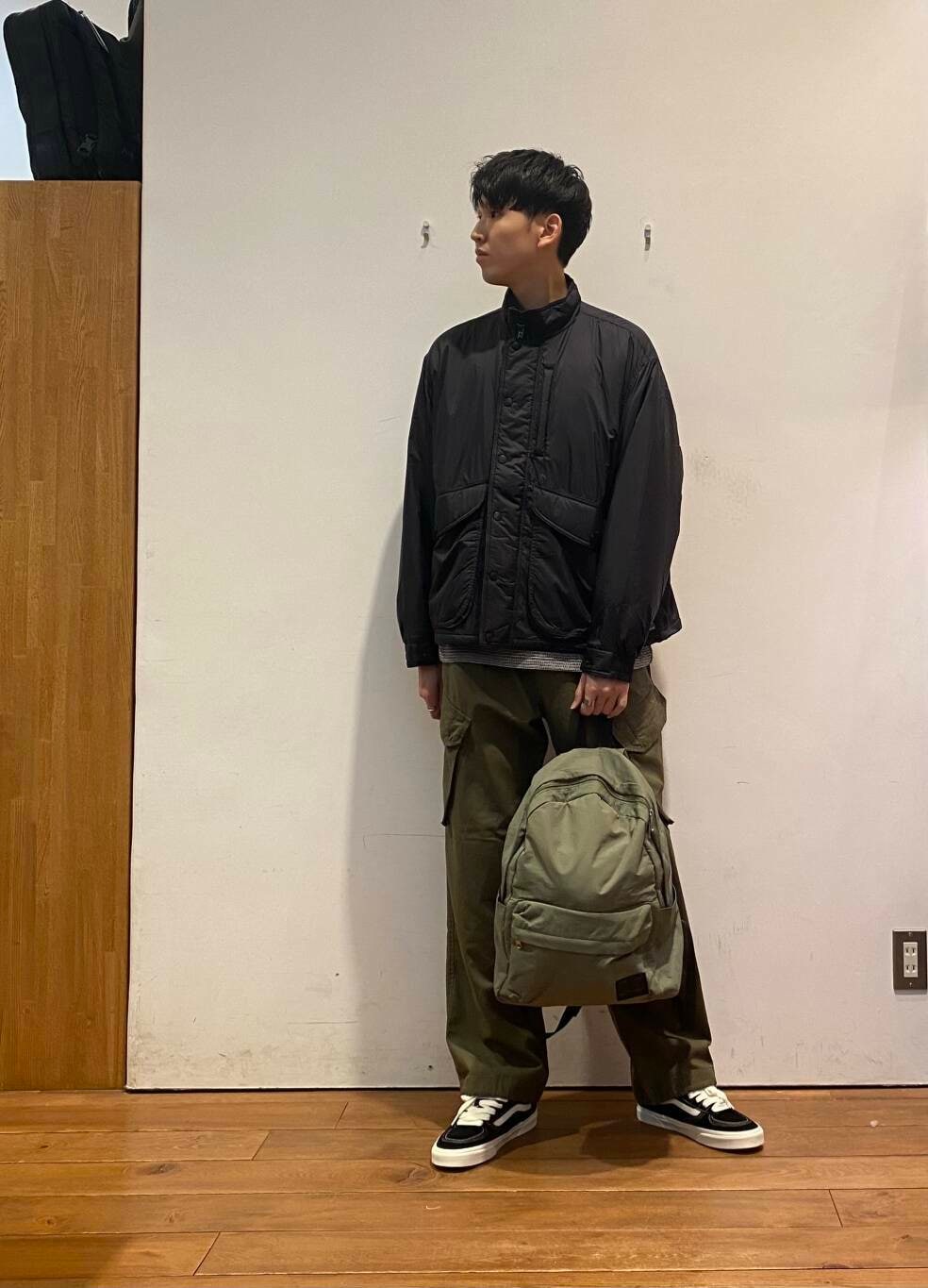 グリーン系のバックパック/リュック、ブラック系のTシャツ/カットソー、グリーン系のその他パンツを着用したメンズの秋コーディネートの2枚目の写真