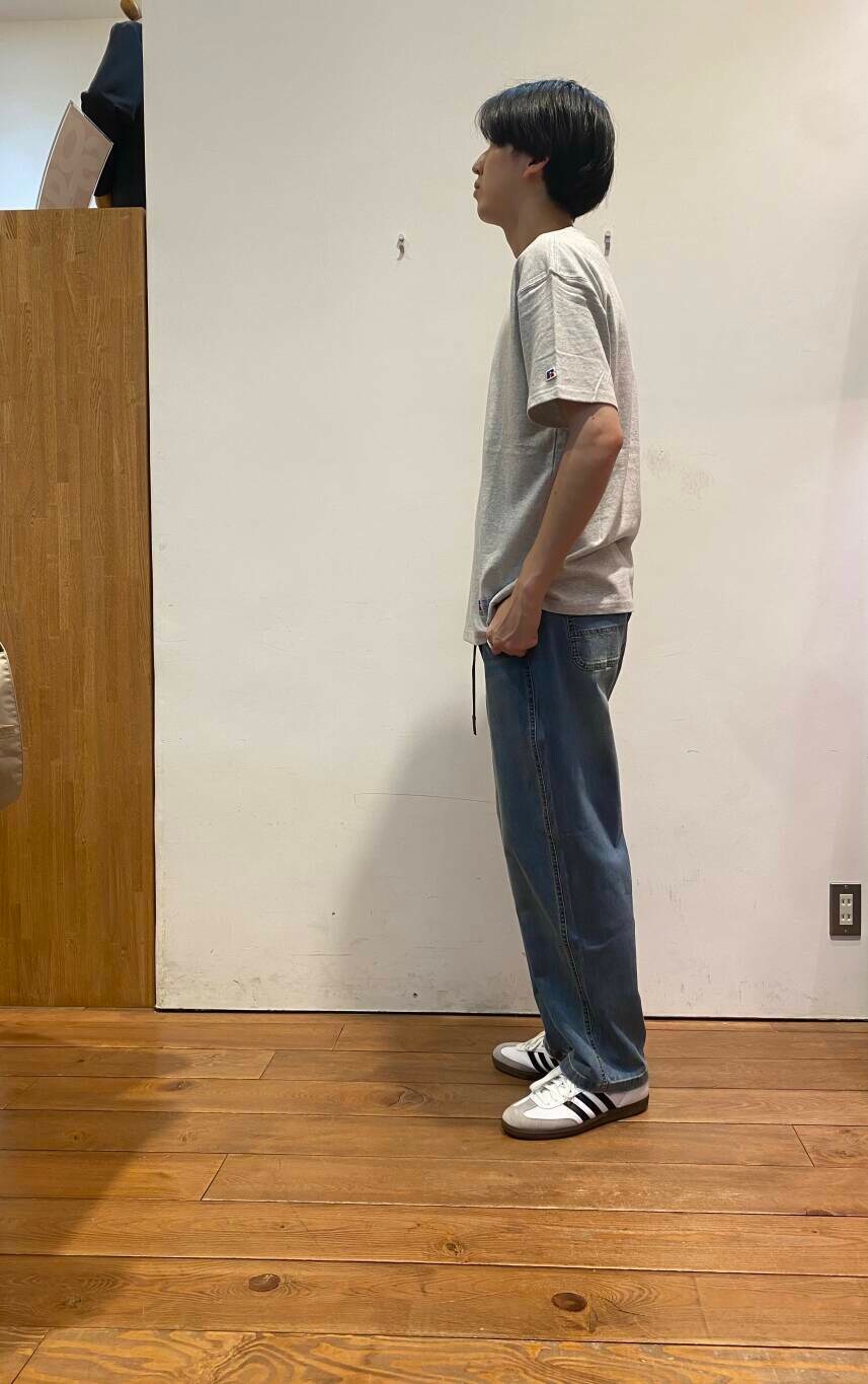 ブルー系のデニムパンツ、ベージュ系のショルダーバッグ、ホワイト系のスニーカーを着用したメンズの夏コーディネートの5枚目の写真