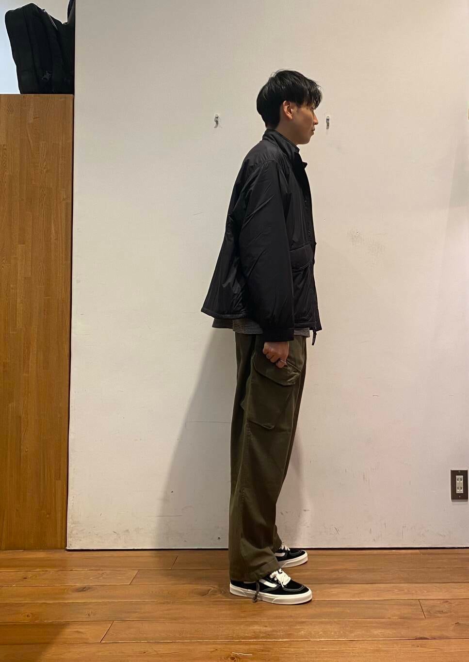 グリーン系のバックパック/リュック、ブラック系のTシャツ/カットソー、グリーン系のその他パンツを着用したメンズの秋コーディネートの6枚目の写真