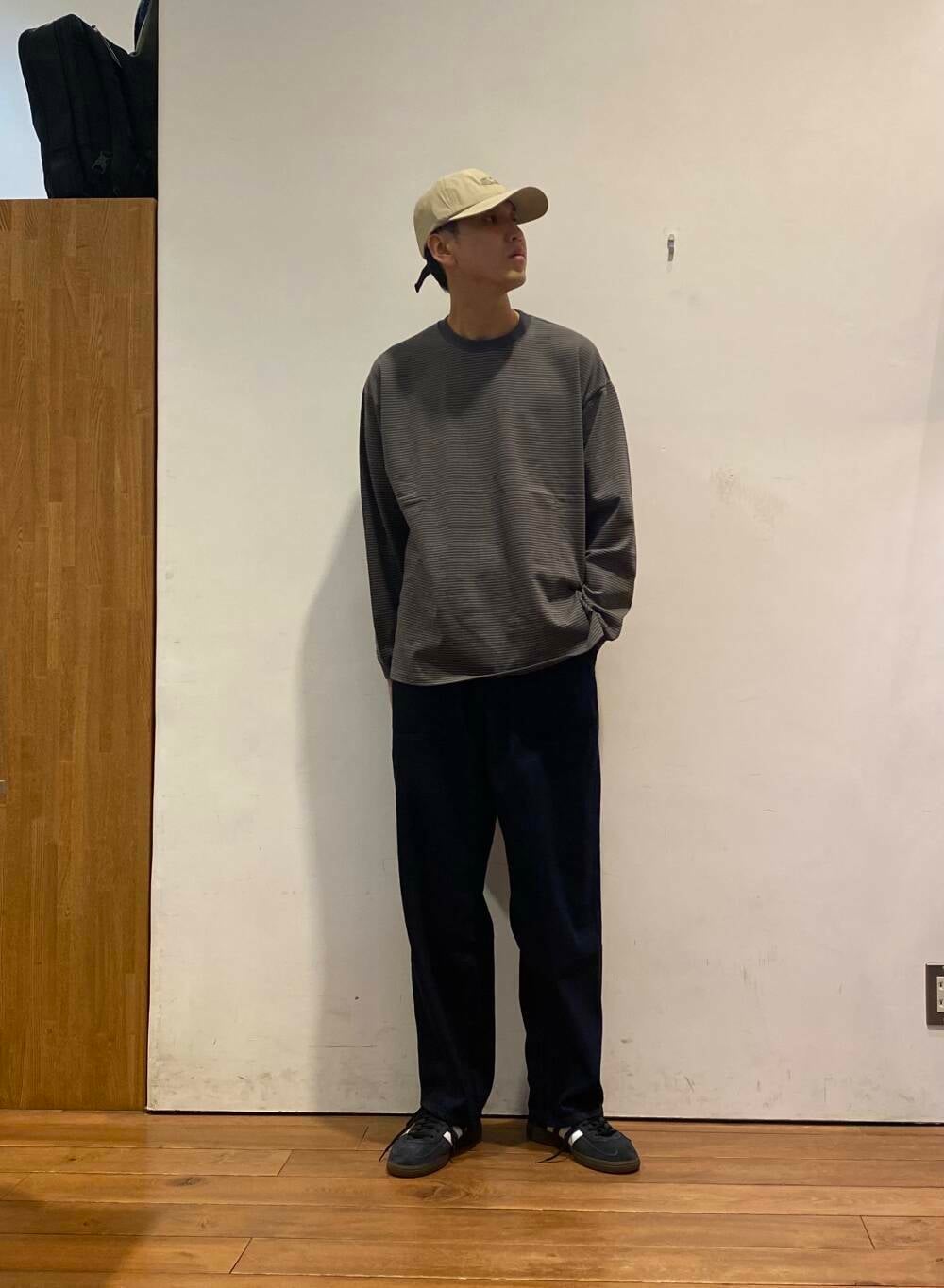 ブラック系のスニーカー、ブルー系のデニムパンツ、グレー系のTシャツ/カットソーを着用したメンズの秋コーディネートの2枚目の写真