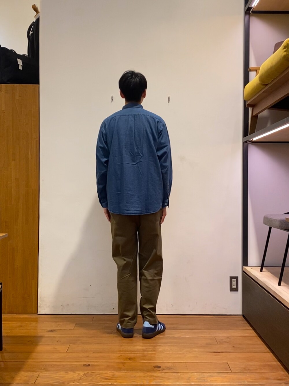ブルー系のスニーカー、ブラック系のテーラードジャケット、グリーン系のその他パンツを着用したメンズの秋コーディネートの6枚目の写真