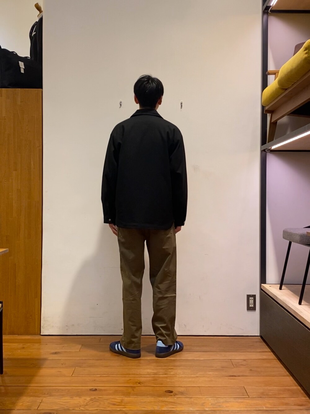 ブルー系のスニーカー、ブラック系のテーラードジャケット、グリーン系のその他パンツを着用したメンズの秋コーディネートの4枚目の写真