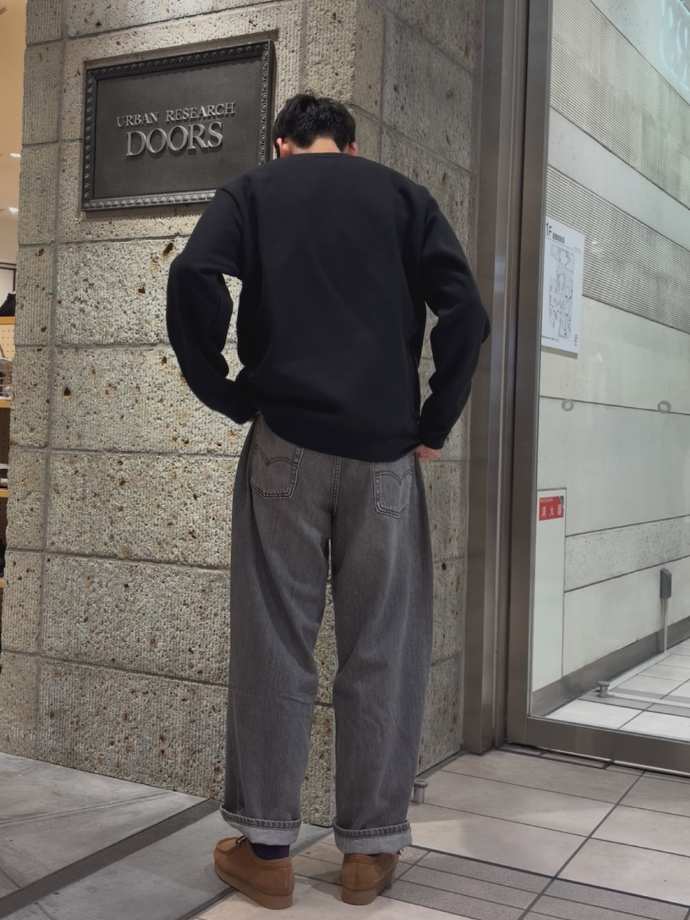 ブラック系のスウェット、ブラック系のデニムパンツ、ブラウン系のブーツを着用したメンズの秋コーディネートの2枚目の写真