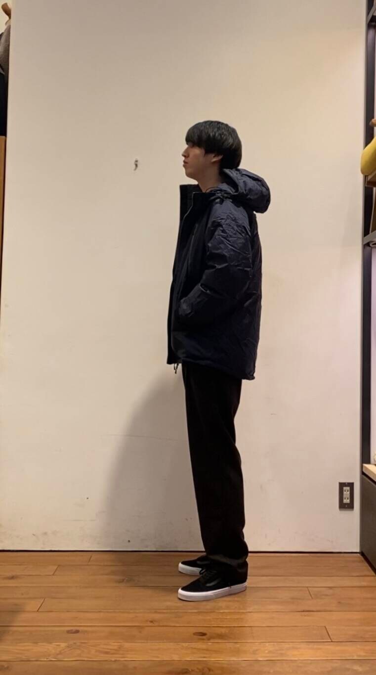 ブルー系のダウンジャケット/コート、ホワイト系のTシャツ/カットソー、ブラウン系のその他パンツを着用したメンズの冬コーディネートの2枚目の写真