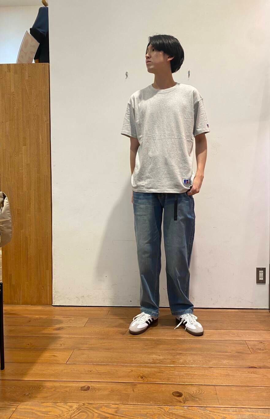 ブルー系のデニムパンツ、ベージュ系のショルダーバッグ、ホワイト系のスニーカーを着用したメンズの夏コーディネートの4枚目の写真