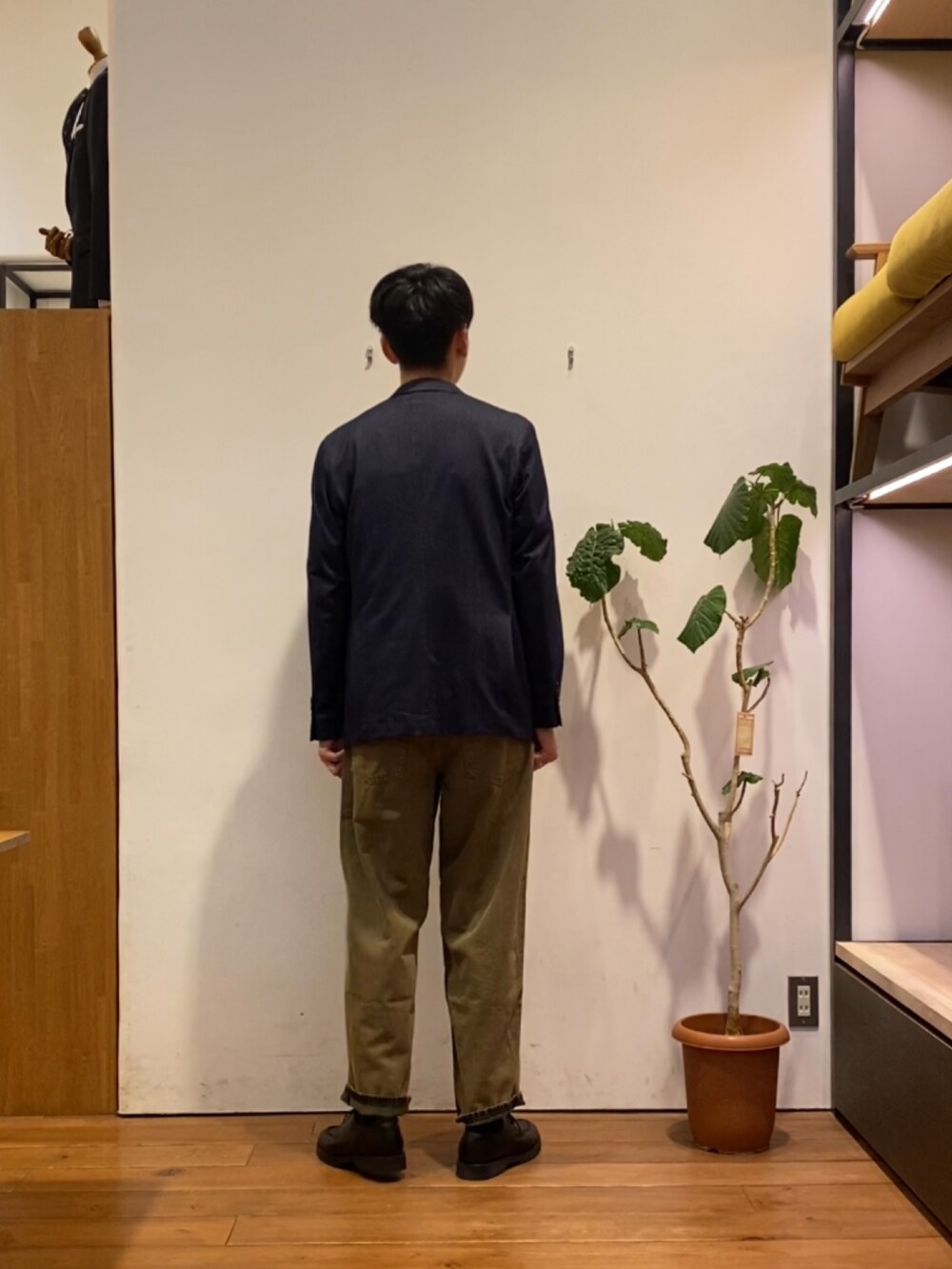 ブラウン系のデニムパンツ、ブラック系のドレスシューズ、ホワイト系のTシャツ/カットソーを着用したメンズの秋コーディネートの4枚目の写真