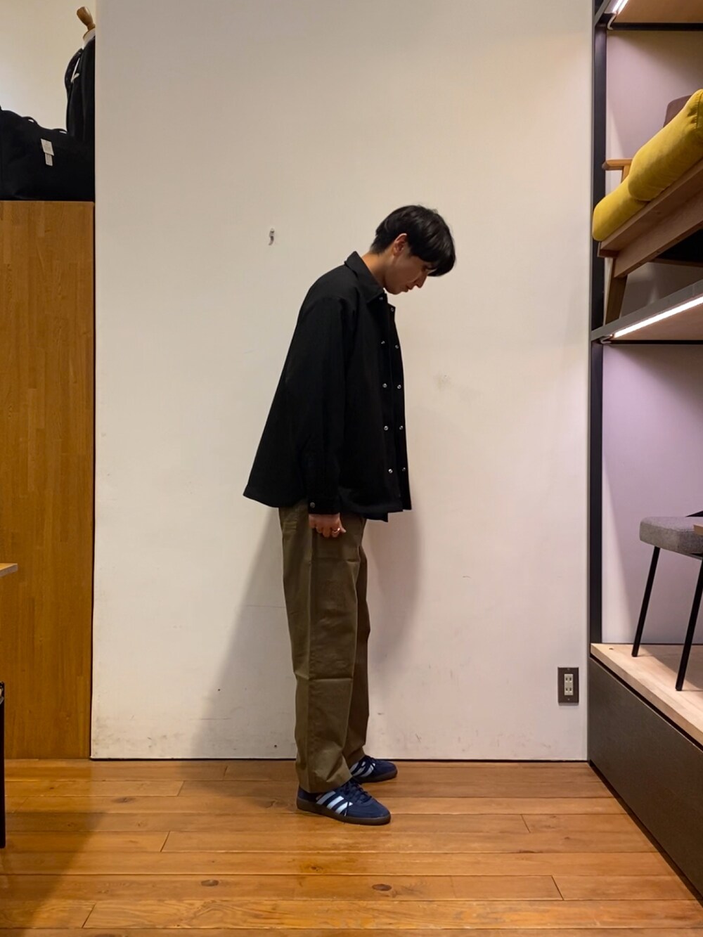 ブルー系のスニーカー、ブラック系のテーラードジャケット、グリーン系のその他パンツを着用したメンズの秋コーディネートの3枚目の写真