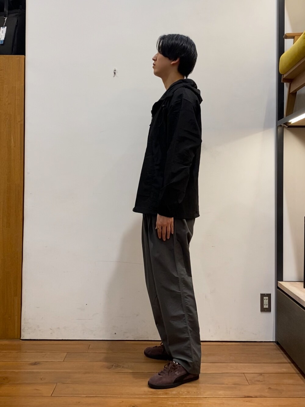 ブラック系のパーカー、グレー系のその他パンツ、ブラウン系のスニーカーを着用したメンズの冬コーディネートの5枚目の写真