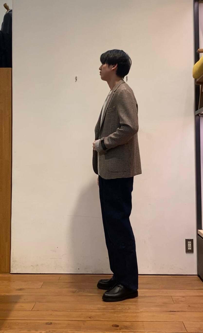 ブルー系のデニムパンツ、グレー系のニット/セーター、ブラウン系のその他アウターを着用したメンズの冬コーディネートの2枚目の写真