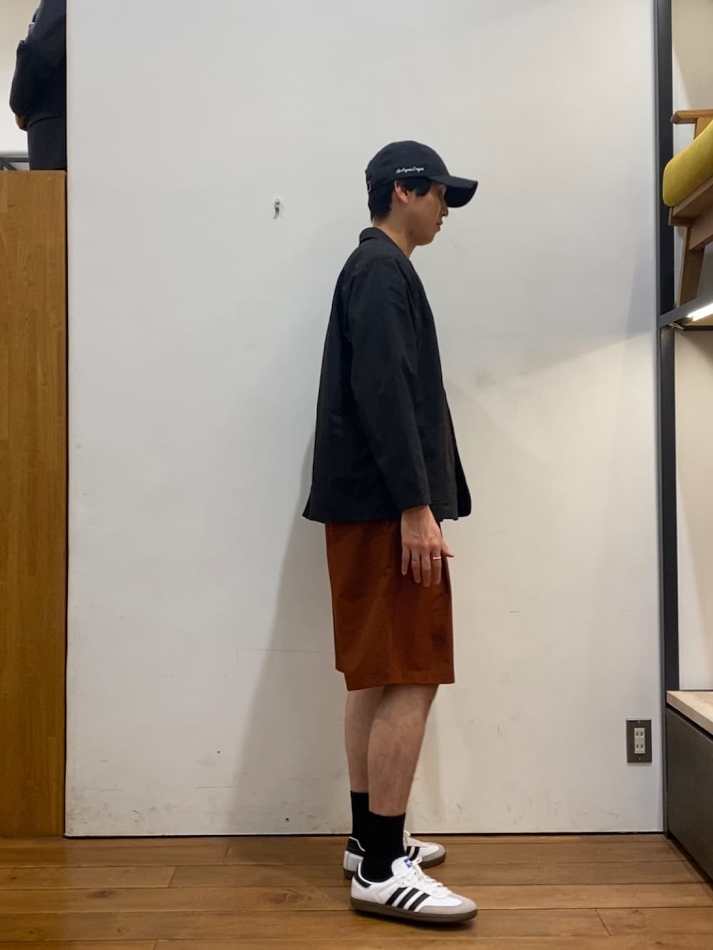 ブラック系のその他アウター、ブラウン系のTシャツ/カットソー、オレンジ系のその他パンツを着用したメンズの春コーディネートの3枚目の写真