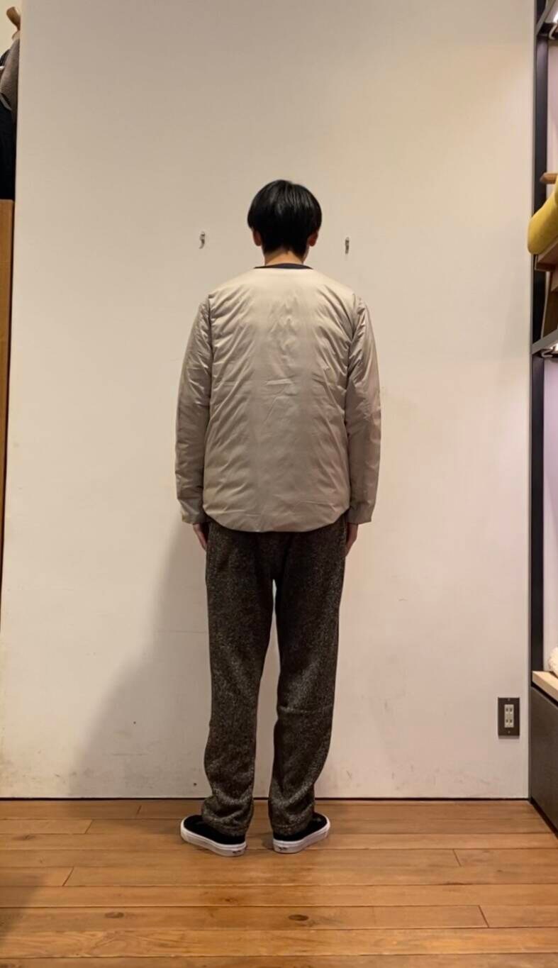 ホワイト系のダウンジャケット/コート、ブルー系のニット/セーター、ブラウン系のその他パンツを着用したメンズの冬コーディネートの2枚目の写真