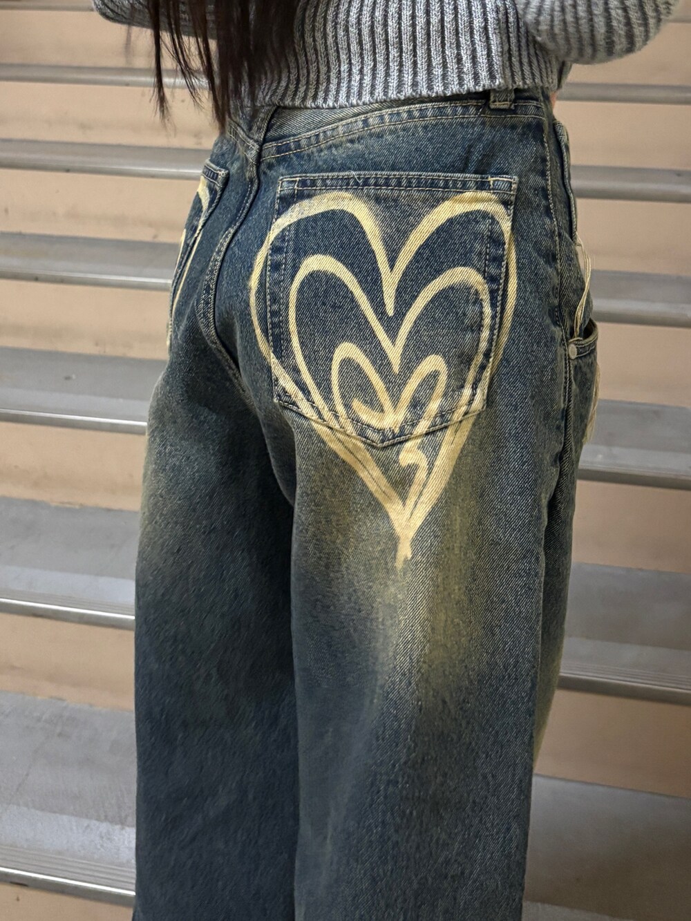 ブルー系のデニムパンツ、グレー系のニット/セーター、ブラック系のブーツを着用したレディースの冬コーディネートの4枚目の写真