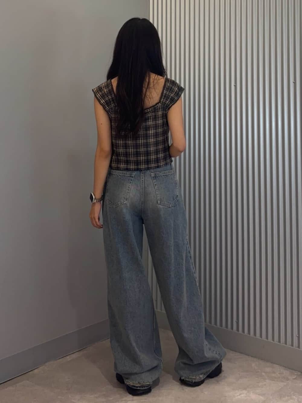 ブラック系のサンダル、ブルー系のデニムパンツ、ブラウン系のタンクトップを着用したレディースの夏コーディネートの3枚目の写真