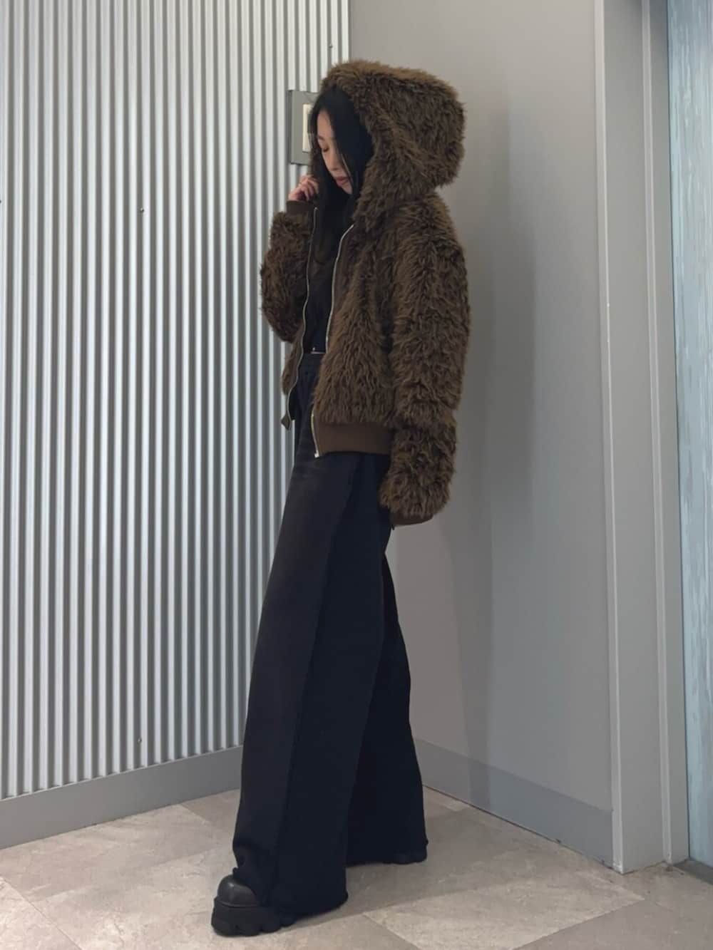 ブラウン系のブルゾン、その他のニット/セーター、ブラック系のスウェットパンツを着用したレディースの冬コーディネートの4枚目の写真