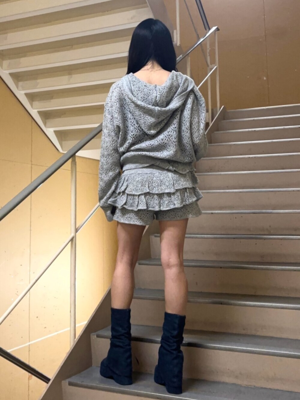 グレー系のパーカー、グレー系のスカート、ブルー系のサンダルを着用したレディースの春コーディネートの3枚目の写真