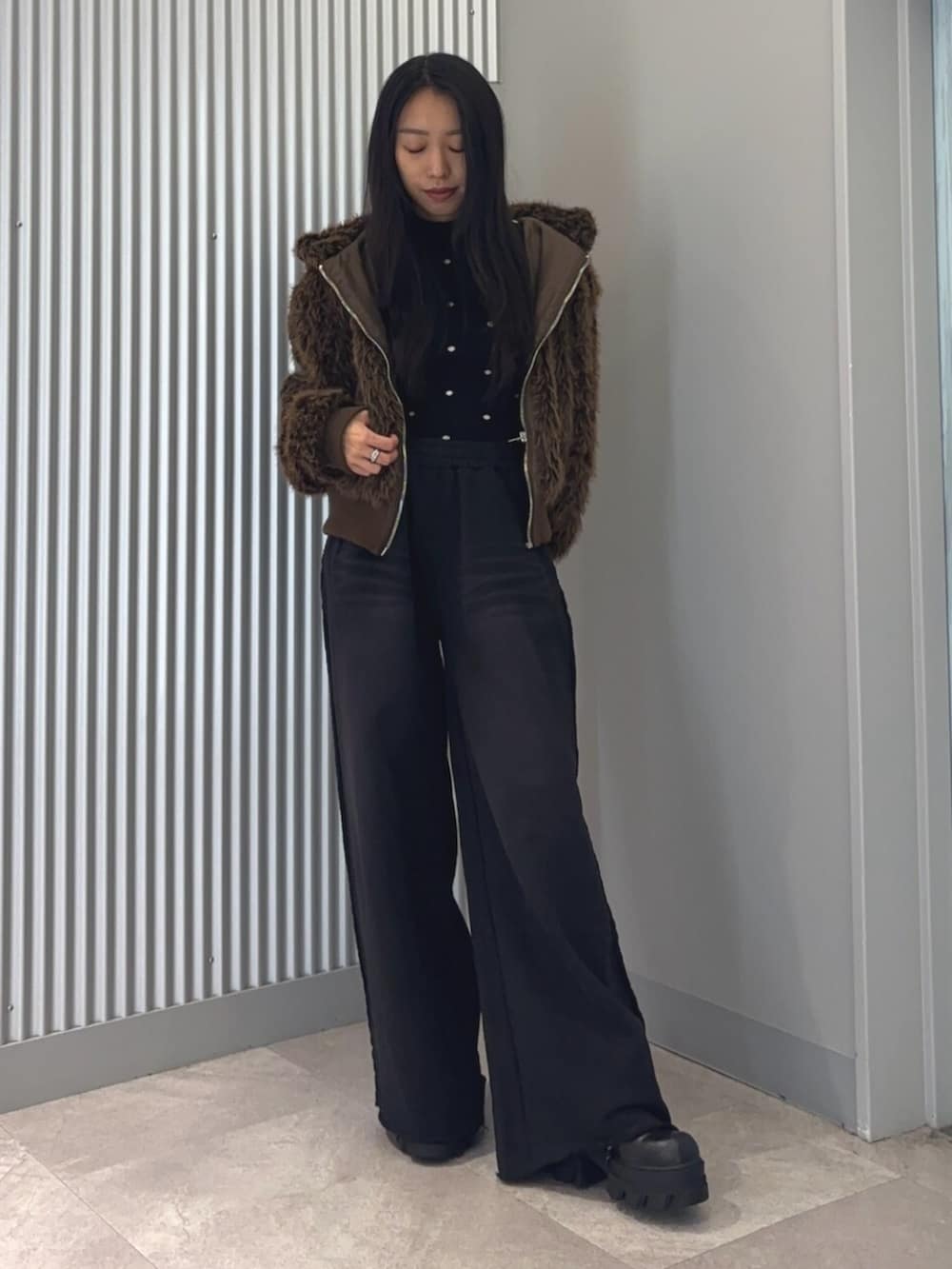 ブラウン系のブルゾン、その他のニット/セーター、ブラック系のスウェットパンツを着用したレディースの冬コーディネートの2枚目の写真