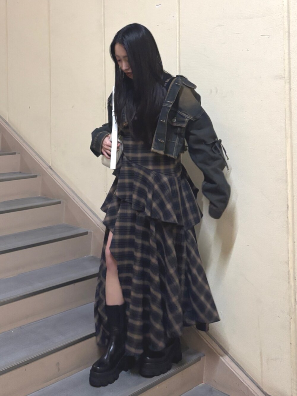 ブラック系のブーツ、ブルー系のデニムジャケット、ブルー系のワンピースを着用したレディースの春コーディネートの2枚目の写真